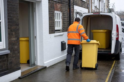 Clinical waste containers being wheeled from a London clinic to a van