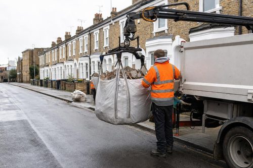 Builders bags of rubble being lifted by a grab lorry in London